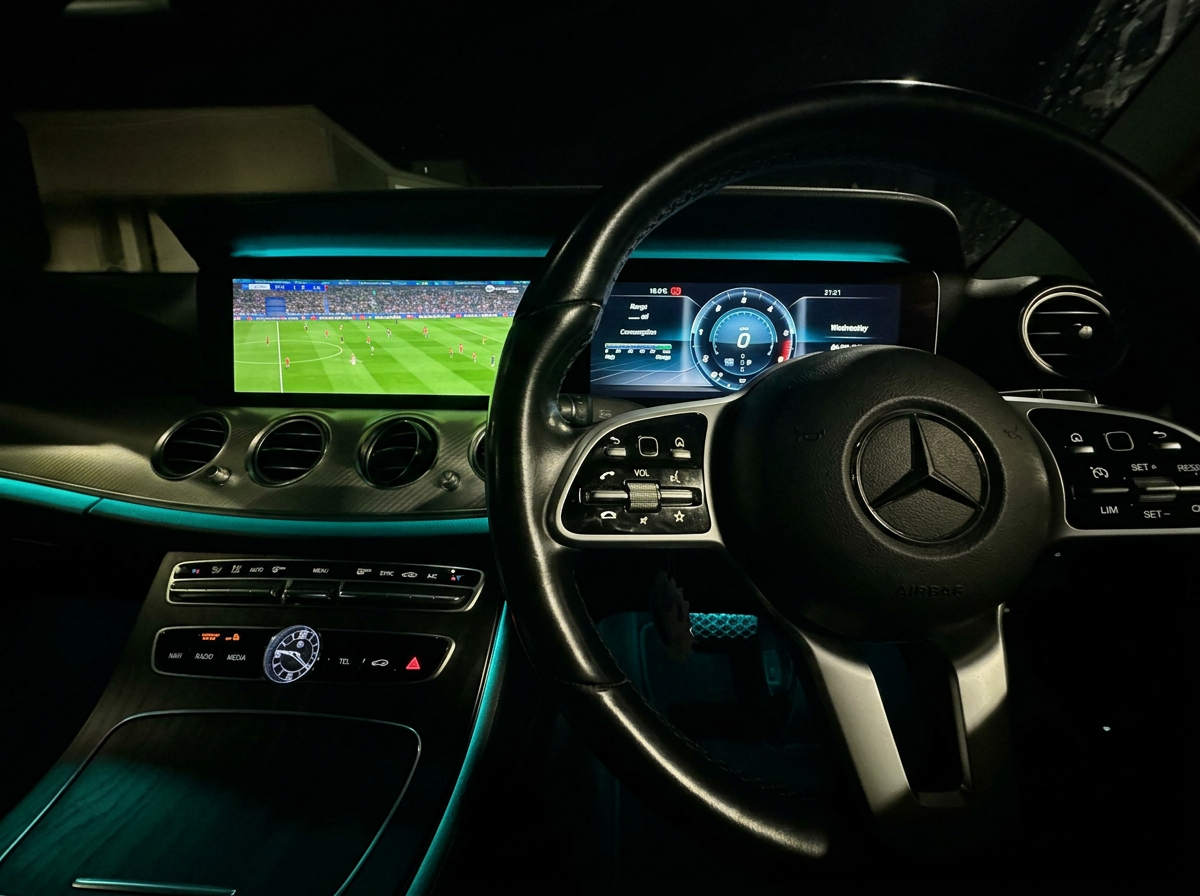 Mercedes-Benz E-Class interior with teal ambient lighting at night